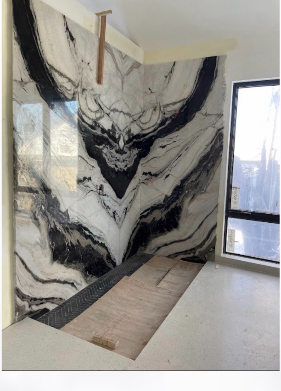 Book matched marble fireplace surround being installed Chicago