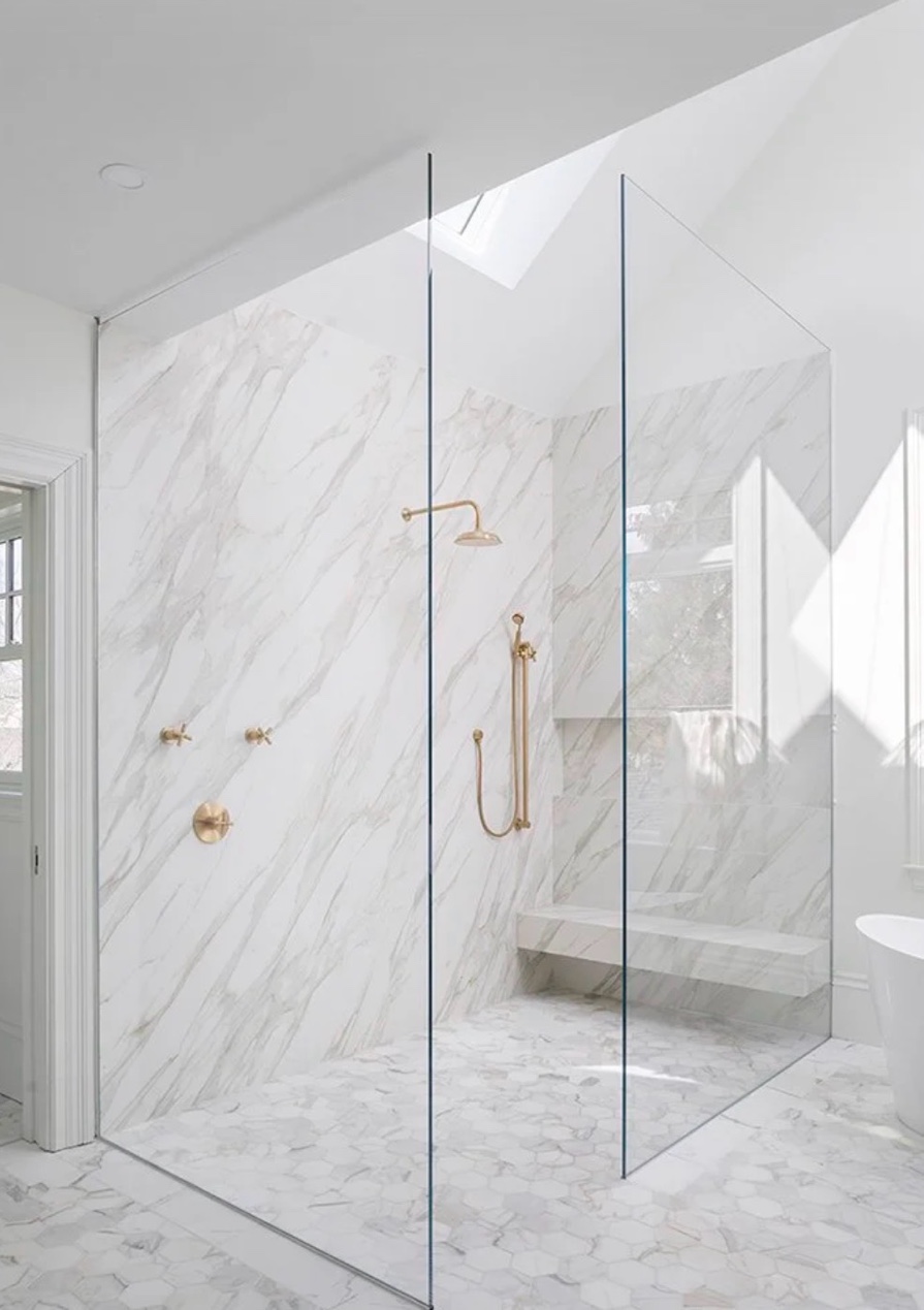 Full marble shower surround gold fixtures skylight Chicago